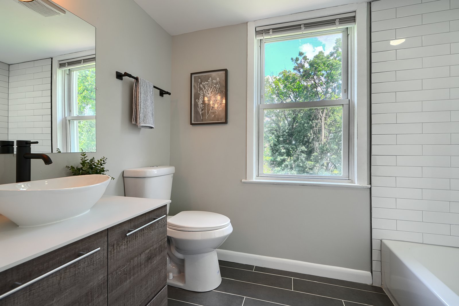 Upstairs bathroom with vessel sink vanity and white subway tile