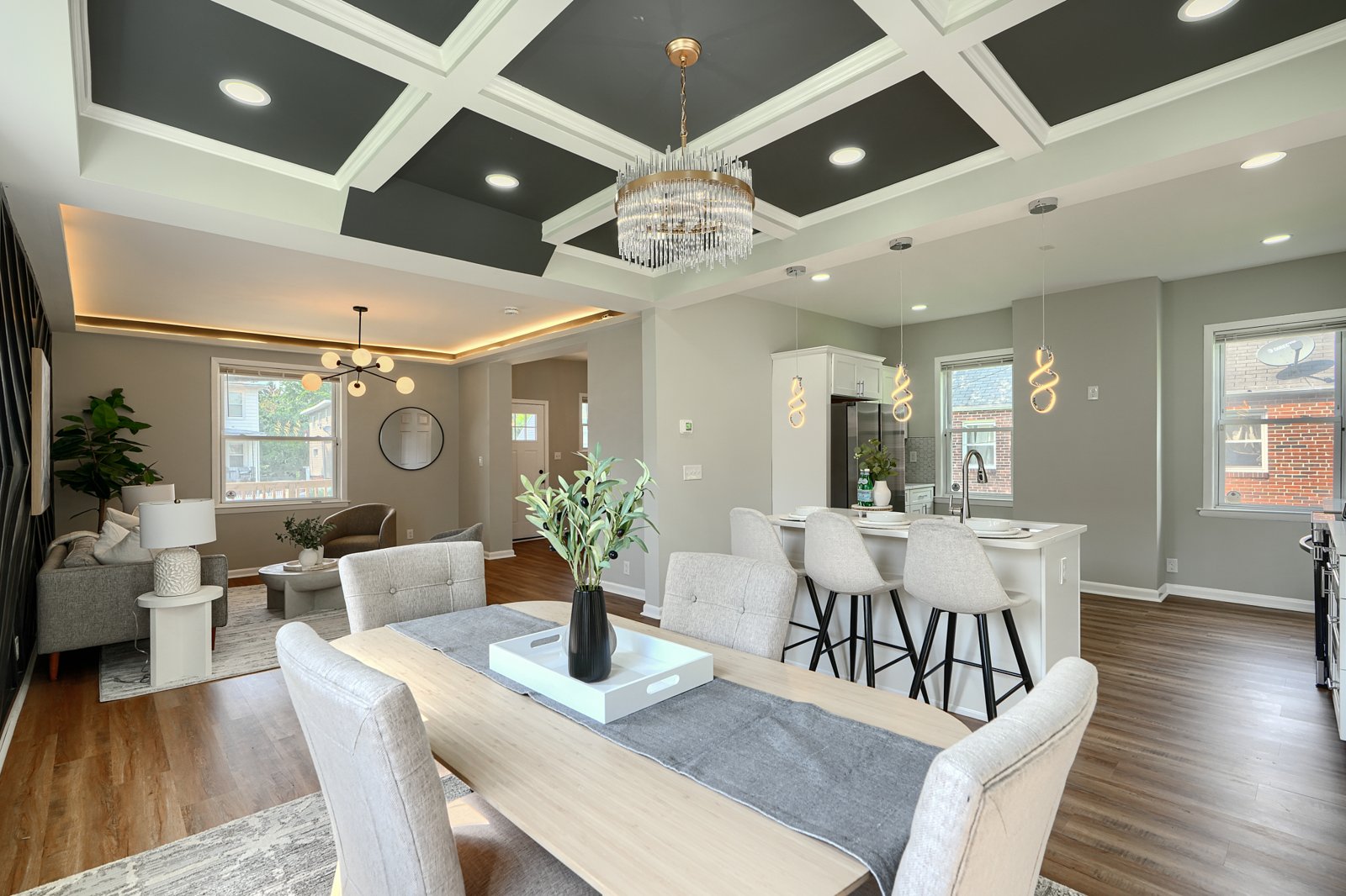 Dining area with coffered ceiling and open concept flow to kitchen and living room