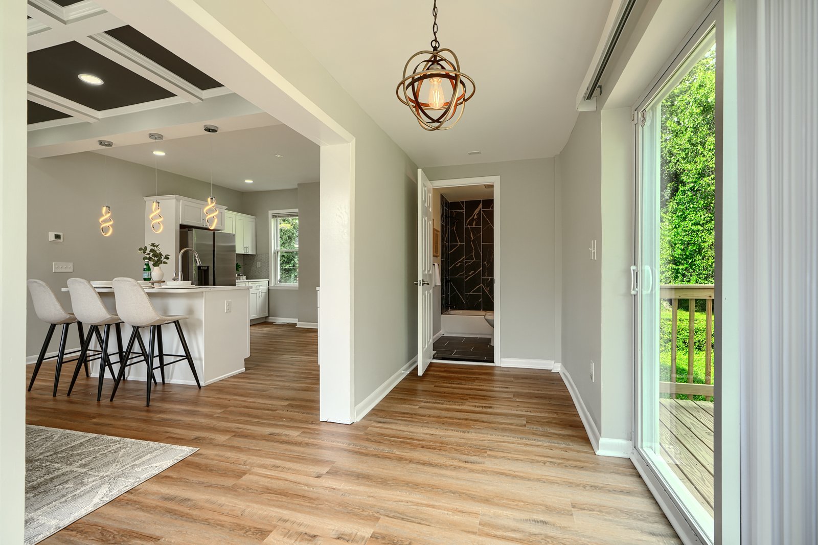 Family room with orb chandelier and sliding glass door to deck