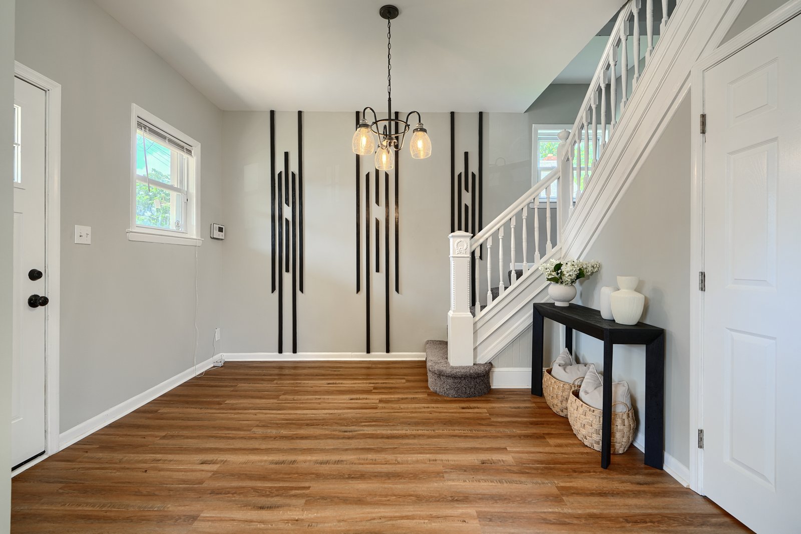 Foyer with white staircase and art deco accent wall