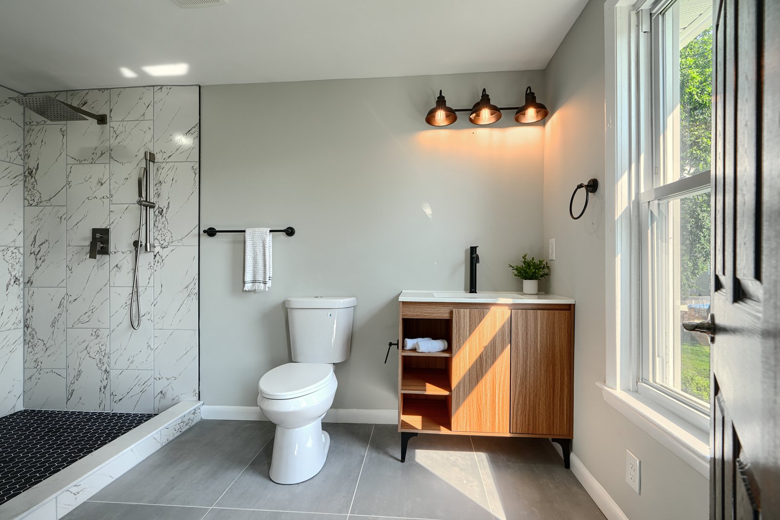 Master bathroom with marble walk-in shower and copper light fixtures