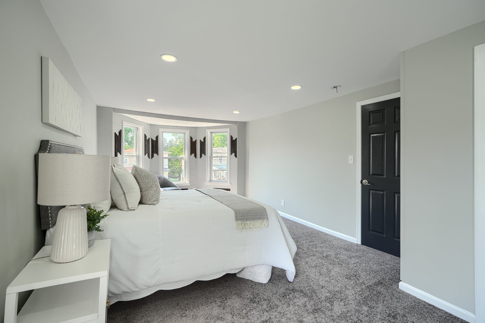 Master bedroom with bay window and recessed lighting