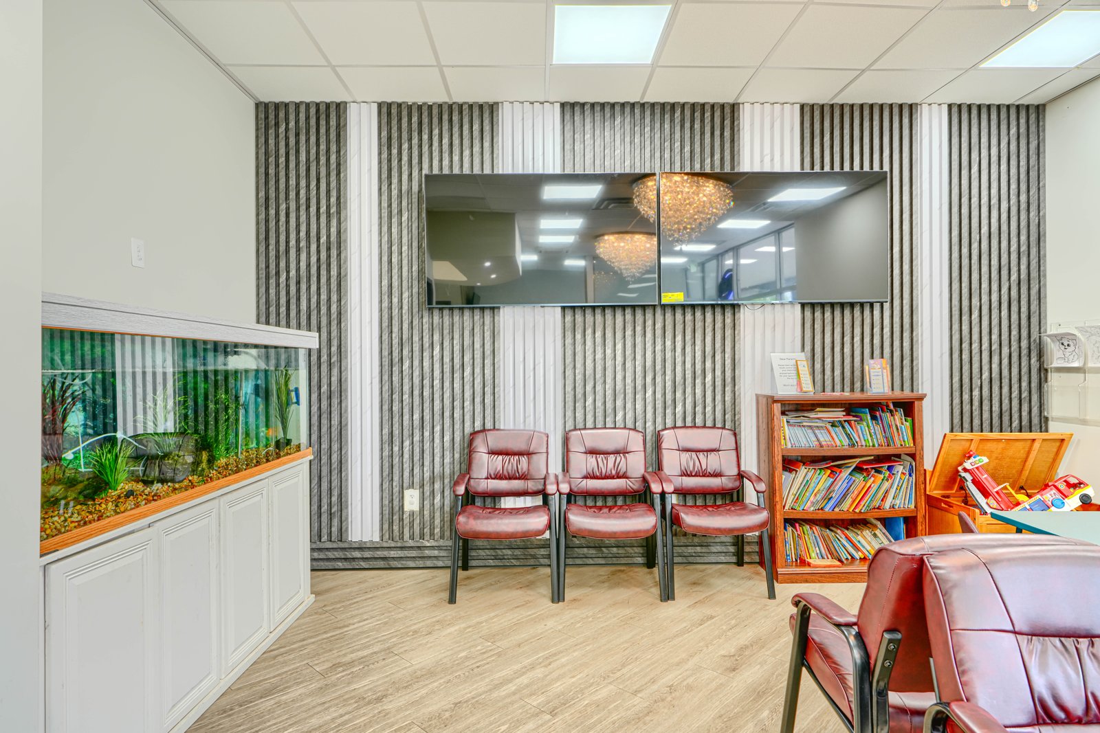 Waiting area featuring built-in aquarium and textured accent wall panels