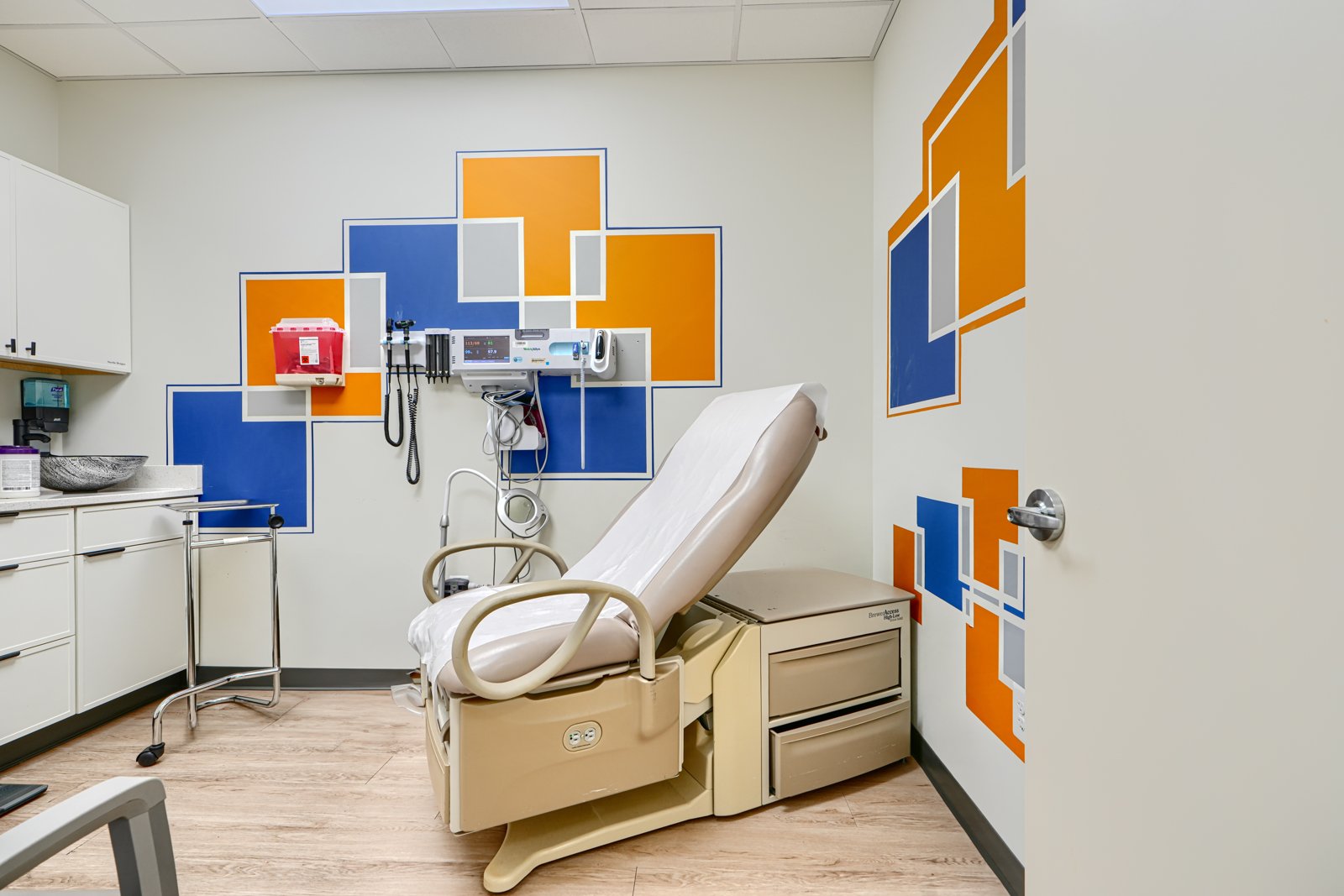 Exam room with blue and orange geometric rectangles mural