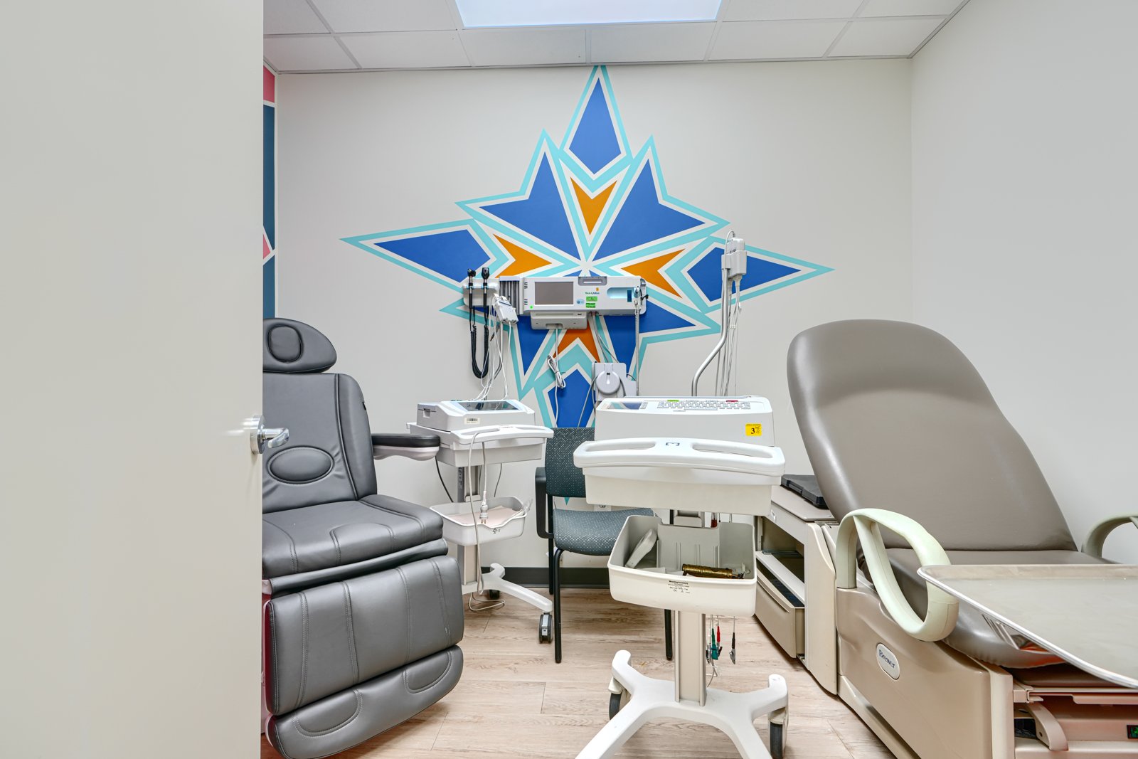 Exam room with blue and orange star compass wall mural